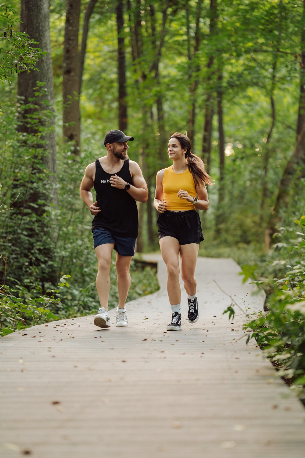 Dwoje ludzi biegnących w naturze - symbol zdrowia i wolności